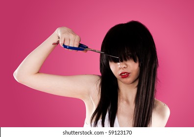 Young Woman Cutting Her Fringe Over Pink Background