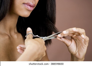 A Young Woman Cutting Her Hair, Trimming The Ends