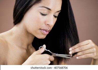 A Young Woman Cutting Her Hair, Trimming The Ends