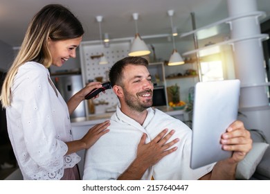 Young Woman Cutting Man's Hair Using Electric Razor Machine At Home. 