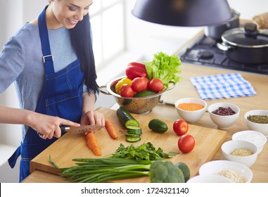 Junge Frau, die zu Hause Gemüse in der Küche schneidet