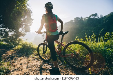 Young woman cyclist  enjoy the beautiful sunrise on summer forest trail - Shutterstock ID 1194096463