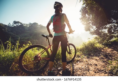 Young woman cyclist  enjoy the beautiful sunrise on summer forest trail - Powered by Shutterstock