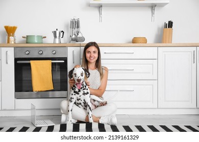 Young Woman With Dalmatian Dog In Kitchen