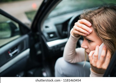 Young Woman In The Damaged Car After A Car Accident, Making A Phone Call.