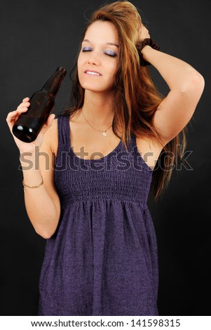 Young woman dancing and drinking a beer at a party