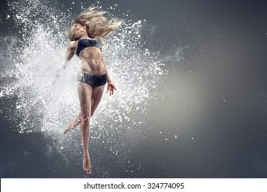 Young woman dancing inside cloud of dust