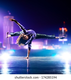 Young woman dancing on city background.