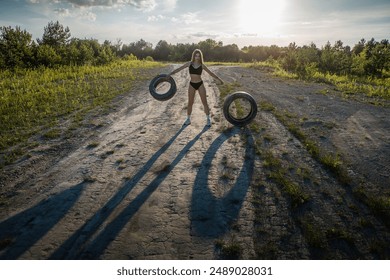 A young woman deals with car tires. - Powered by Shutterstock