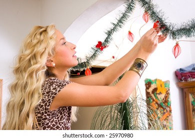 A young woman decorating her house for Christmas.