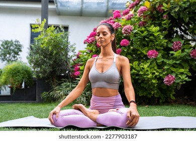 Young woman in deep meditation. sitting on yoga ma tin beautiful garden  - Shutterstock ID 2277903187