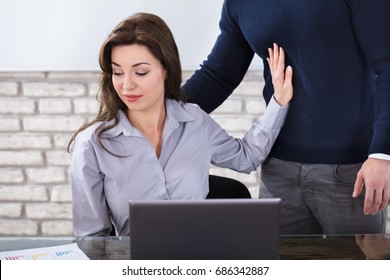 Young Woman Defending Herself For Sexual Harassment In Business Office