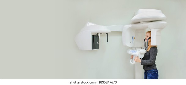 Young woman in a dental 3D x-ray digital scanner panorama machine in clinic. Copy space for you text