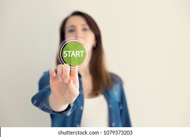 Young Woman Designer Touching Virtual Button Start. New Start, Beginning, Business Concept