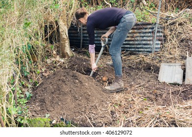 A Young Woman Is Digging A Hole In A Garden