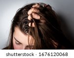 Young woman with dirty greasy hair on gray background. 