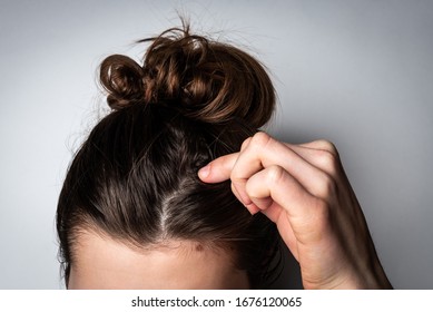 Young Woman With Dirty Greasy Hair On Gray Background. 