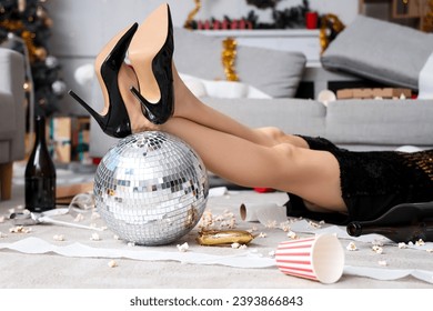 Young woman with disco ball lying in messy living room after New Year party, closeup - Powered by Shutterstock