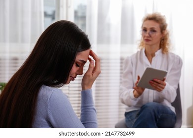 Young woman in distress on a psychological therapy session. A conversation between psychologist and her client in the office. Copy space, background. - Shutterstock ID 2147732499