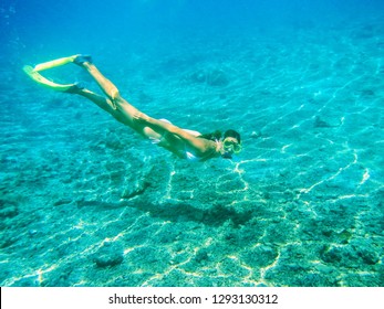 Young Woman Diving With Snorkel In Clear Water Near Tropical Island