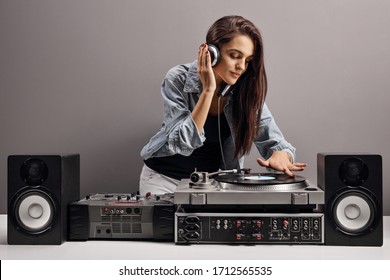 Young woman dj playing music on a gray background - Powered by Shutterstock