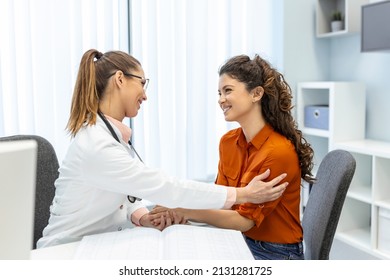 Young Woman Doctor Or GP In White Medical Uniform Consult Female Patient In Private Hospital. Female Therapist Speak Talk With Woman Client On Consultation In Clinic.