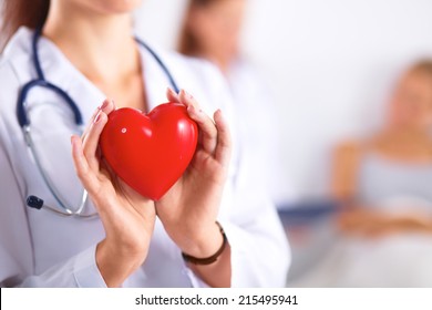 Young Woman Doctor Holding A Red Heart, Isolated On White Background