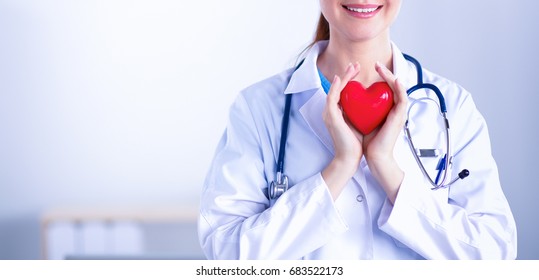 Young woman doctor holding a red heart, isolated on white background - Shutterstock ID 683522173