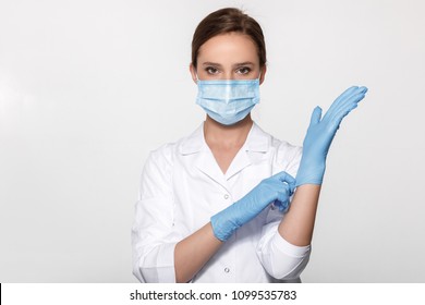 Young woman doctor in white uniform wearing mask and gloves