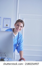 Young Woman Doctor At Work While Pointing At Computer In Hospital Office.