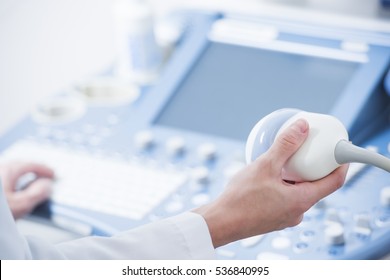 young woman doctor's hands close up preparing for an ultrasound device scan.