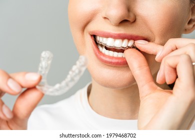 A young woman does a home teeth whitening procedure. Whitening tray with gel - Shutterstock ID 1979468702