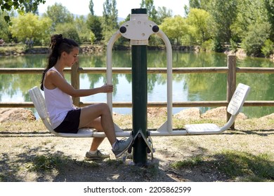 Young Woman Does Sports In A Public Gym In A Park