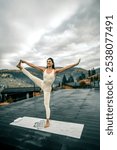 A young woman does yoga on the hotel terrace overlooking the autumn mountains. The concept of yoga and meditation. Asanas.