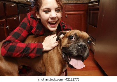 Young Woman With A Dog In The Kitchen.