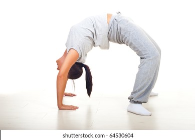 Young Woman Doing Back Bend On Floor Over White Background