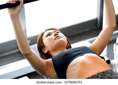 Young Woman Doing Bench Press At The Gym