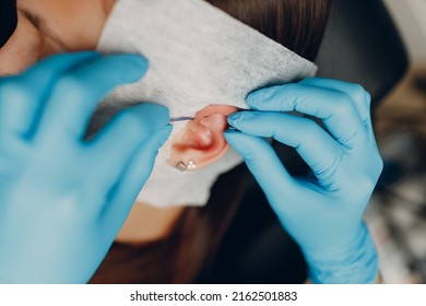 Young Woman Doing Ear Piercing At Beauty Studio Salon