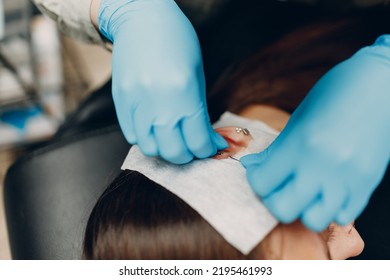 Young Woman Doing Ear Piercing At Beauty Studio Salon