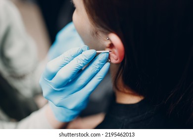 Young Woman Doing Ear Piercing At Beauty Studio Salon