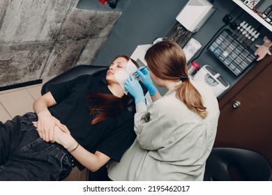 Young Woman Doing Ear Piercing At Beauty Studio Salon