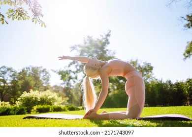 Young Woman Doing Excercise At The Public Park. Fitness Woman Doing Yoga Exercises In The Morning. Sport, Active Life.