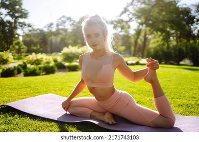 Young Woman Doing Excercise At The Public Park. Fitness Woman Doing Yoga Exercises In The Morning. Sport, Active Life.