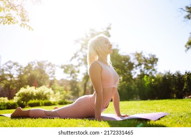 Young Woman Doing Excercise At The Public Park. Fitness Woman Doing Yoga Exercises In The Morning. Sport, Active Life.