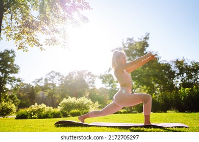 Young Woman Doing Excercise At The Public Park. Fitness Woman Doing Yoga Exercises In The Morning. Sport, Active Life.