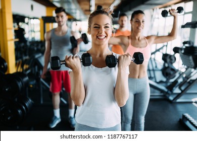 Young Woman Doing Exercise With Dumbbell In Gym