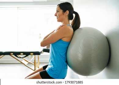 A young woman doing exercise on fitness ball at the physiotherapy office