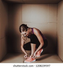 Young Woman Doing Exercises In Cardboard Box. Young Smiling Girl. Life In Little Cardboard Box. Uncomfortable Life. Personal Spase Concepts. Young Introvert. Sports And Healthy Lifestyle.