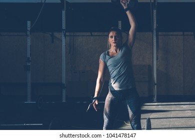 Young woman doing exercises with dumbbell at box on a fitness session