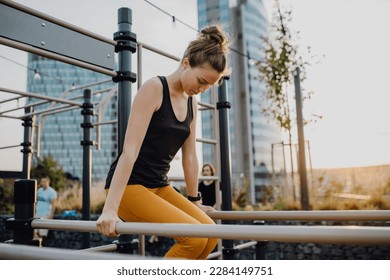 Young woman doing exercises at outdoor work-out city park. - Powered by Shutterstock